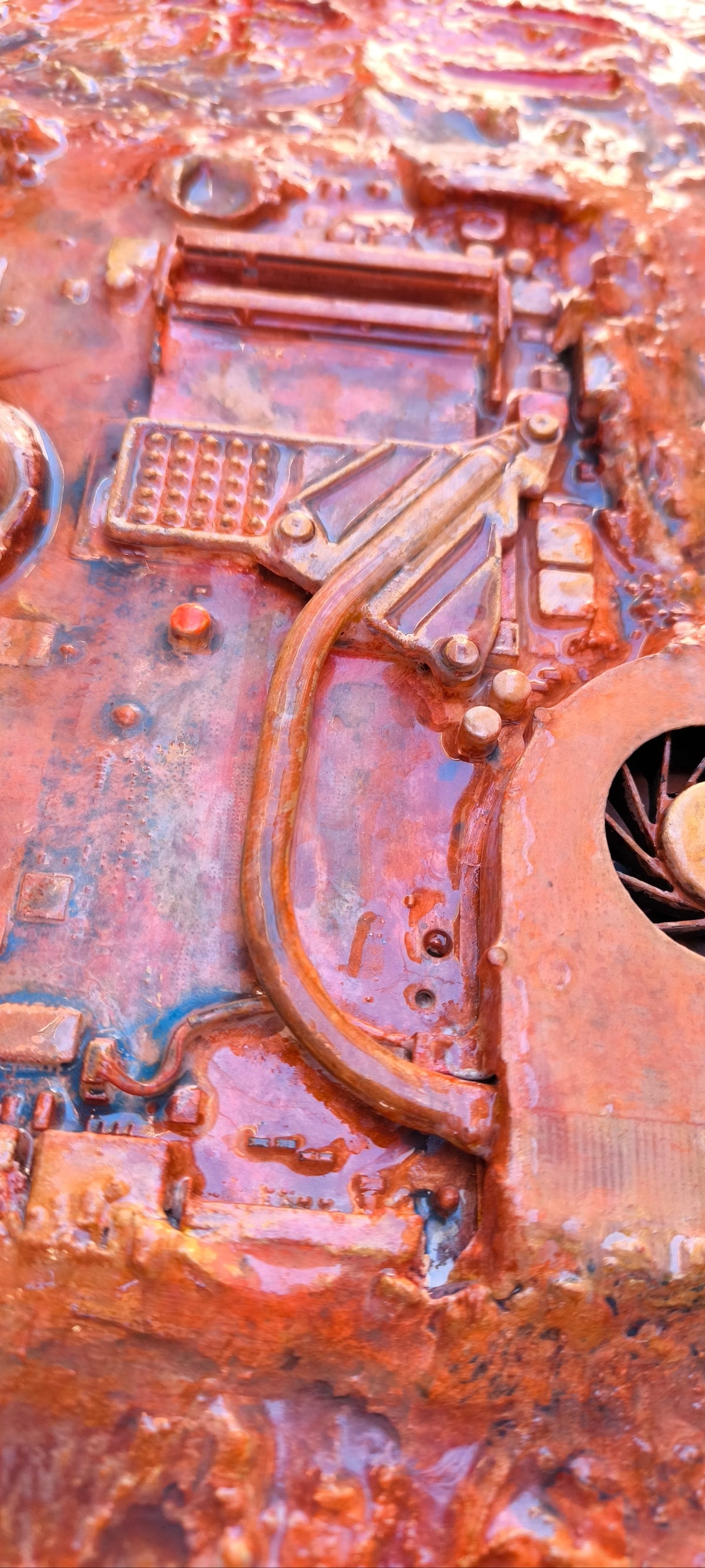 Détail en vue de dessous des connexions et du ventilateur de computer qui devient une usine vue du ciel. Technique collage de pièces industrielles en recyclage artistique unique, texturres sables et pigments de Roussillon en Provence, œuvre contemporaine de François Tapiézo.