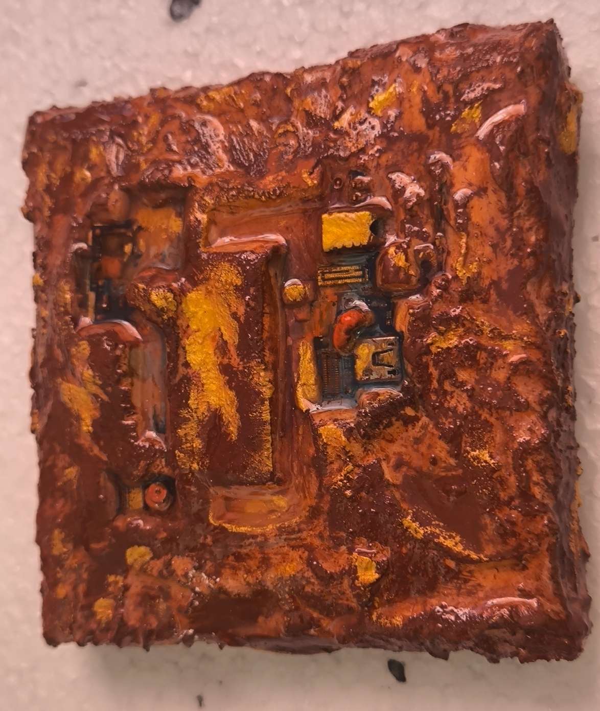 Détails en vue latérale de carte électronique de téléphone sublimée dans des textures de sables et pigments ocrés de Provence. Matières rehausées d'or. Peinture contemporaine en relief 3d de François Tapiézo.