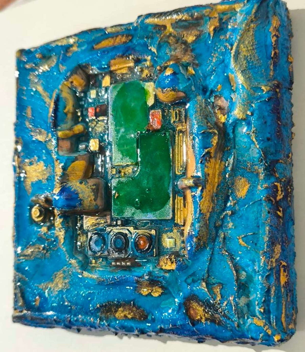 Détails en vue latérale art contemporain texturé avec carte électronique et matières de sables et pigments de Provence. Recyclage en relief rehaussé d'or par François Tapiézo.