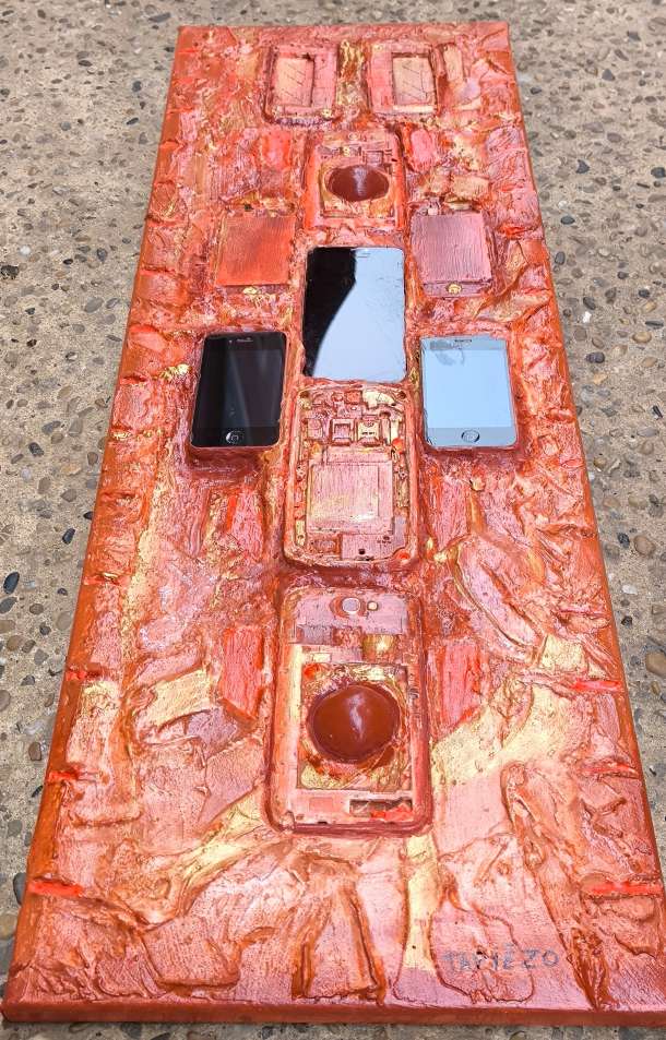 Vue par dessous des téléphones mobiles en escadrille. Totem électronique dans les textures de sable et pigments de Provence par François Tapiézo.