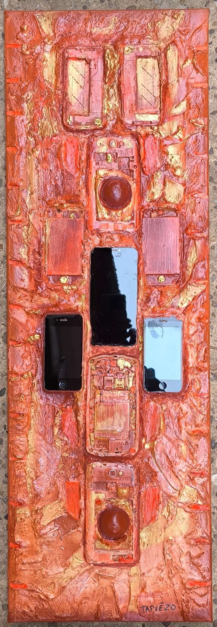 Découvrir cet art contemporain en relief avec de vrais téléphones mobiles immergés dans les textures et matières de sable et pigments de Roussillon par François Tapiézo. Un recyclage de phones unique.